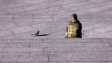 Ein Bundeswehr-Soldat sitzt auf einer Steintreppe (Symbolbild) | Bild: picture alliance / Geisler-Fotopress | Christoph Hardt/Geisler-Fotopres